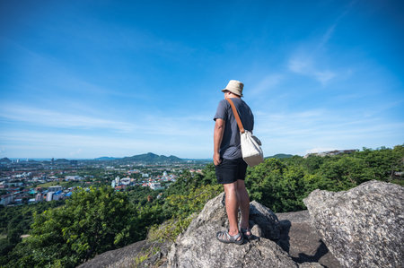 Asian fat man stand on the rock  at Khao hin lek fai view point.Khao Hin Lek Fai is a place to see a spectacular view of the entire town.Also know as khao radar in local people.の写真素材