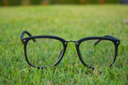 The glasses on the grass field with copy space with bokeh backgroundの写真素材