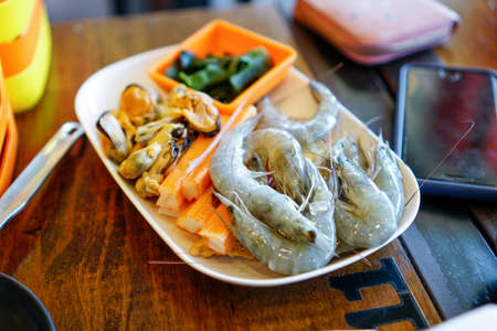Fresh raw shrimps set with vegatables on the bamboo basket ready for cooking with copy spaceの写真素材
