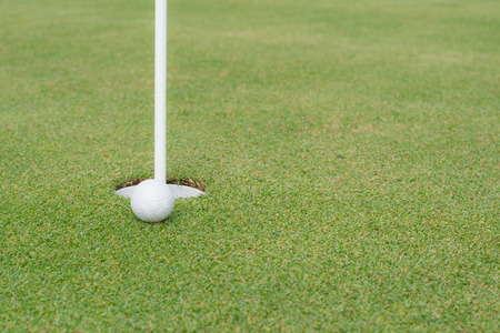 Golf ball at the edge of the holeの写真素材