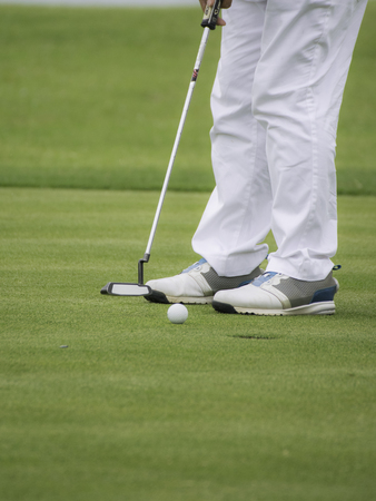 Low angle view of golfer on putting greenの写真素材