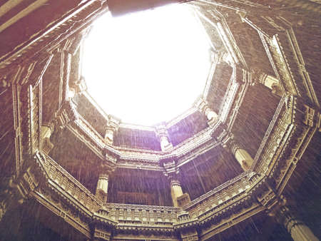 The entire structure is built in the architectural style of the Solankis and sandstone is used as the primary component. One of the most outstanding a defining feature of the step well is the octagonal shaped roof from where some light comes through but mostly protects the insides from harsh summer days and functions as a real oasis. The landings, levels and the roofs are present in the form of big openings which makes this place very breathable and airy. Another significant feature of the step well which sets it apart from the rest is the fact that it can be approached from 3 different main entries which are equally beautified. All the motifs, moldings and the carvings on the walls depict the deities, mythological creatures, flowers and tells us everything about the queen and the masons responsible for the creation of this magnificent structure that has been admired for centuries and generations.の写真素材