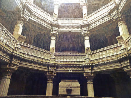 The entire structure is built in the architectural style of the Solankis and sandstone is used as the primary component. One of the most outstanding a defining feature of the step well is the octagonal shaped roof from where some light comes through but mostly protects the insides from harsh summer days and functions as a real oasis. The landings, levels and the roofs are present in the form of big openings which makes this place very breathable and airy. Another significant feature of the step well which sets it apart from the rest is the fact that it can be approached from 3 different main entries which are equally beautified. All the motifs, moldings and the carvings on the walls depict the deities, mythological creatures, flowers and tells us everything about the queen and the masons responsible for the creation of this magnificent structure that has been admired for centuries and generations.の写真素材