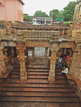 The entire structure is built in the architectural style of the Solankis and sandstone is used as the primary component. One of the most outstanding a defining feature of the step well is the octagonal shaped roof from where some light comes through but mostly protects the insides from harsh summer days and functions as a real oasis. The landings, levels and the roofs are present in the form of big openings which makes this place very breathable and airy. Another significant feature of the step well which sets it apart from the rest is the fact that it can be approached from 3 different main entries which are equally beautified. All the motifs, moldings and the carvings on the walls depict the deities, mythological creatures, flowers and tells us everything about the queen and the masons responsible for the creation of this magnificent structure that has been admired for centuries and generations.の写真素材