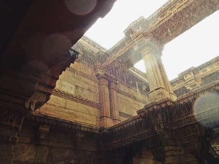 The entire structure is built in the architectural style of the Solankis and sandstone is used as the primary component. One of the most outstanding a defining feature of the step well is the octagonal shaped roof from where some light comes through but mostly protects the insides from harsh summer days and functions as a real oasis. The landings, levels and the roofs are present in the form of big openings which makes this place very breathable and airy. Another significant feature of the step well which sets it apart from the rest is the fact that it can be approached from 3 different main entries which are equally beautified. All the motifs, moldings and the carvings on the walls depict the deities, mythological creatures, flowers and tells us everything about the queen and the masons responsible for the creation of this magnificent structure that has been admired for centuries and generations.の写真素材