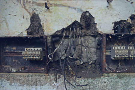 old electrical box with broken wires in the wall, closeup of photoの写真素材