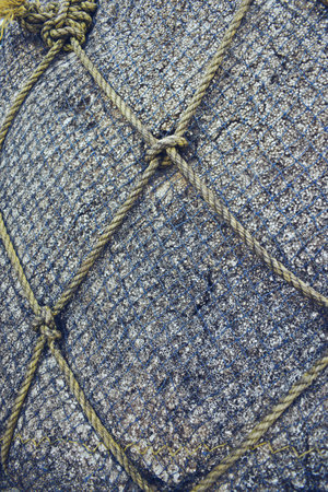 Close up of a fishing net with ropes on a fishing boat.の写真素材
