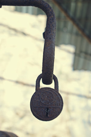 Old rusty padlock on the door of a building, closeup of photoの写真素材