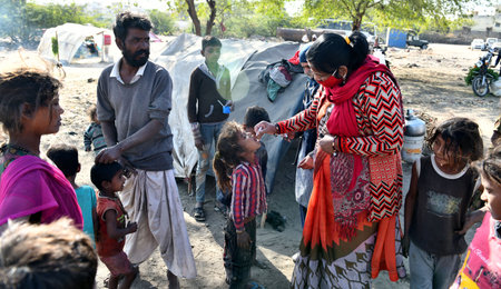 Beawar, Rajasthan, India, Feb. 01, 2021: An Anganwadi health worker administers polio vaccine drops to a child at a slum area during Pulse Polio eradication program in Beawar. Photo: Sumit Saraswatのeditorial素材