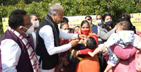 Jaipur, Rajasthan, India, Jan. 31, 2021: Rajasthan Chief Minister Ashok Gehlot administers polio drops to a child during polio pulse program in Jaipur. Photo: Sumit Saraswatのeditorial素材