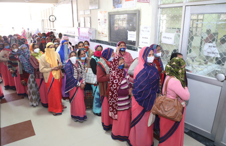 Beawar, Rajasthan, India, Jan. 25, 2021: Anganwadi workers stand in a queue as they wait for their turn to get vaccinated during the COVID-19 vaccination drive at a government hospital in Beawar. Photo: Sumit Saraswatのeditorial素材