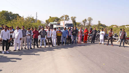 Beawar, Rajasthan, India, Feb. 6, 2021: Farmers and Congress workers formed human chain as they blocked national highway 14 during nationwide chakka jam to support ongoing agitation against government's farm reform laws, in Beawar. Protesters chanting sloのeditorial素材