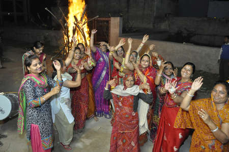 Beawar, Rajasthan, India, March 5, 2015: Hindu devotees dance around the bonfire during Holika Dahan on Holi, the spring festival of colours, in Beawar. Photo: Sumit Saraswatのeditorial素材