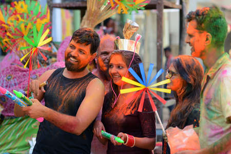 Beawar, Rajasthan, India, March 2, 2018: Indian family buys toys from a street vendor as they celebrate Holi, the spring festival of colours, in Beawar. Photo: Sumit Saraswatのeditorial素材