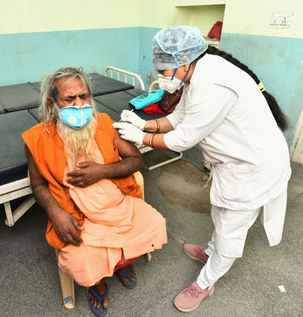 Beawar, Rajasthan, India, March 2, 2021: An elderly monk being administered COVID-19 vaccine, during a countrywide inoculation drive, at Government hospital in Beawar. Photo: Sumit Saraswatのeditorial素材