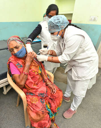 Beawar, Rajasthan, India, March 2, 2021: An elderly woman being administered COVID-19 vaccine, during a countrywide inoculation drive, at Government hospital in Beawar. Photo: Sumit Saraswatのeditorial素材