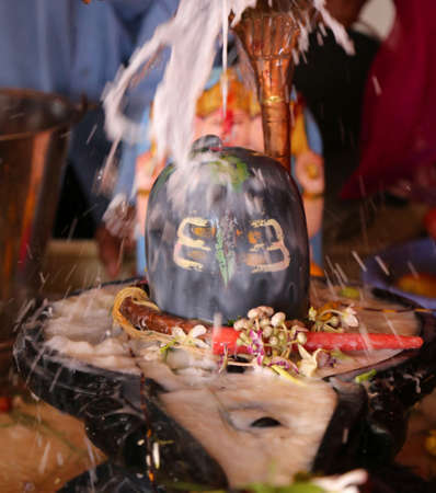 Milk pour over a Lingam, a stone sculpture representing the Hindu Lord Shiva, on Maha Shivratri festival at Mahadev temple in Beawar, Rajasthan, India. Photo: Sumit Saraswatの写真素材