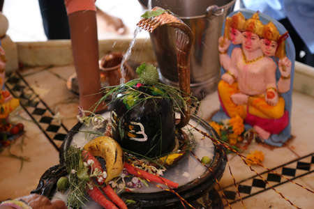 Beawar, Rajasthan, India, March 7, 2016: Indian Hindu devotees pour water and milk over a Lingam, representing Lord Shiva on Maha Shivratri festival at Mahadev temple in Beawar. Photo: Sumit Saraswatのeditorial素材
