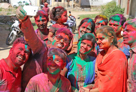 Beawar, Rajasthan, India, March 24, 2016: Group of people clicks selfie as they celebrate Holi, the Hindu spring festival of colors, in Beawar. Photo: Sumit Saraswatのeditorial素材