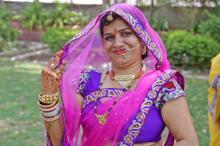 Beawar, Rajasthan, India, April 9, 2016: Portrait of a smiling rajasthani young woman in traditional attire poses for a picture during Gangaur festival celebrations in Beawar. Photo: Sumit Saraswatのeditorial素材