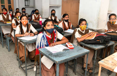Beawar, Rajasthan, India, April 6, 2021: Female students wearing protective face mask as they study in a classroom at a school amid spike in coronavirus cases across the country. Photo: Sumit Saraswatのeditorial素材