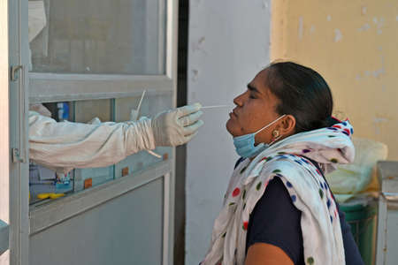 Beawar, Rajasthan, India, May 10, 2021: A health worker collects nasal swab sample from a woman at a COVID-19 testing lab during second wave of coronavirus epidemic, in Beawar. Photo: Sumit Saraswatのeditorial素材