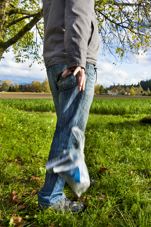 Man throwing garbage on the grassの写真素材