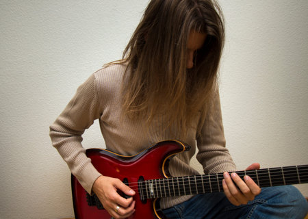 Young man playing a red e-guitar