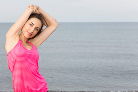 Beautiful fitness woman is stretching her triceps.
