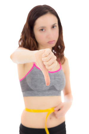 Woman showing thumbs down about her weight loss