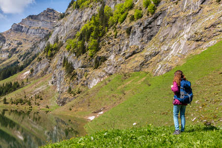 Woman tourist with backpack hiking on Alpsの写真素材