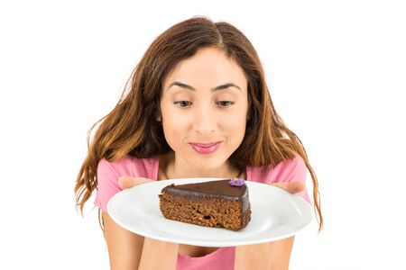 Woman holding a a piece of cake in a plateの写真素材