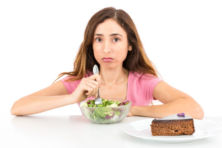Weight loss woman eating salad wishing for a piece of cake