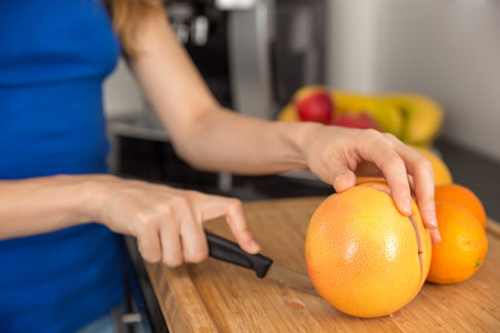 Close up of hands cutting a grapefruitの写真素材
