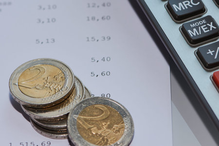 Coin euro on a bill with calculator