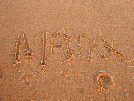 Child has written the word "Mama" in the sand on the beachの写真素材