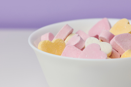 macro color picture of candy hearts in a white bowlの写真素材