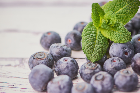 macro photography of blueberries on a white wooden surface with copy spaceの写真素材