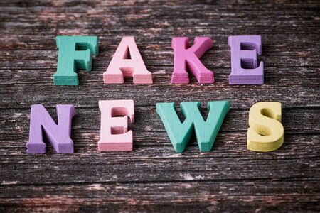 the English words - fake news - laid with wooden letters on wooden backgroundの写真素材
