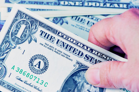 close up of a female hand taking a dollar banknote