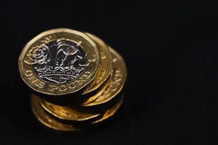 used British one pound coins against black background with copy spaceの写真素材