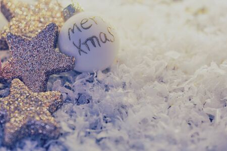 chistmas tree ball with English text - merry xmas- lying beside glittery stars as greeting cardの写真素材