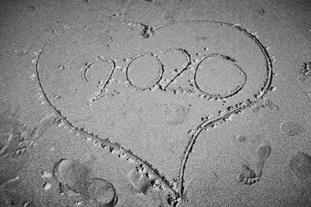 Heart shape in the sand on a beach with the year 2020 in it