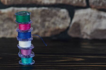 small tower of colored cotton thread on yarn bobbinsの写真素材