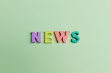 the word -news- is lying on light green background made out of colored letters