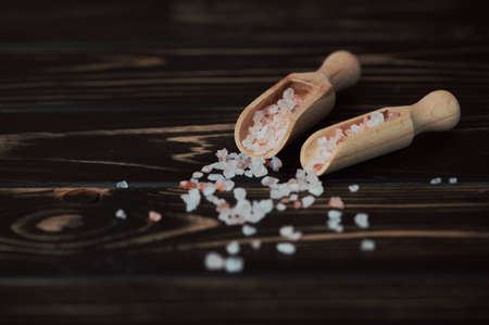 two wooden shovels with himalayan salt on brown backgroundの写真素材