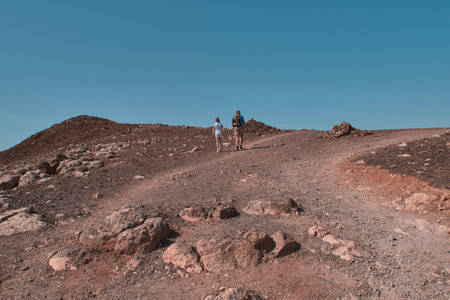 father and daughter are hiking on the red moutain of Lanzarote