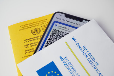 Mainz, Germany - July 16, 2021: Detail photo of a vaccination certificate, a cell phone screen with the QR code of the complete vaccination, as well as the European vaccination certificate.のeditorial素材