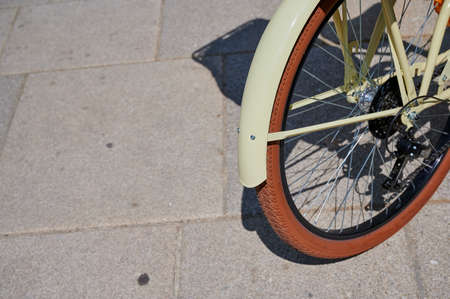 Front wheel of a bicycle in yellow vintage style on asphaltの写真素材