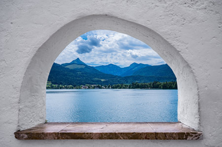view through a stone window to the beautiful landscape of the Wolfgangsee in Austriaの写真素材